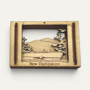 Wooden Matchbox Miniature of the New Hampshire Boat Museum with a runabout on a lake, front view